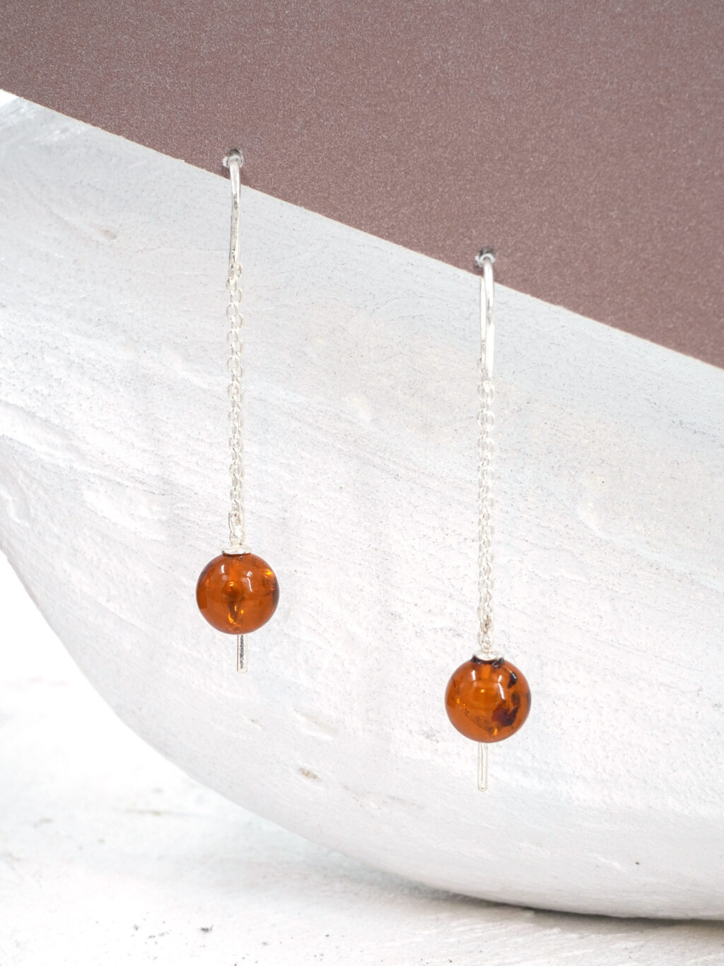 Серебряные серьги цепочки с коньячным янтарем шариком с вкраплениями